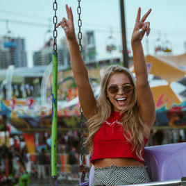 Mujer en un festival, levanta los brazos con emocion